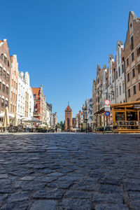 Buildings in city against clear blue sky