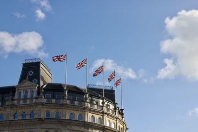 Low angle view of flag on building against sky