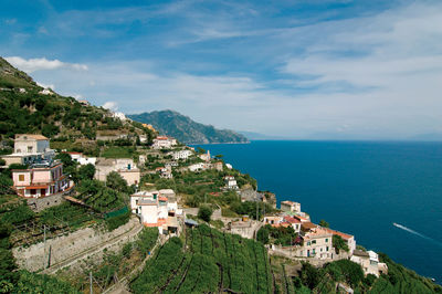 High angle view of townscape by sea against sky