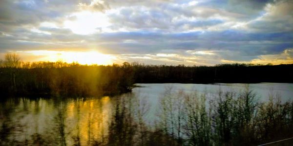 Scenic view of lake against sky at sunset