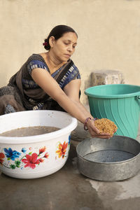 Side view of young woman preparing food at home