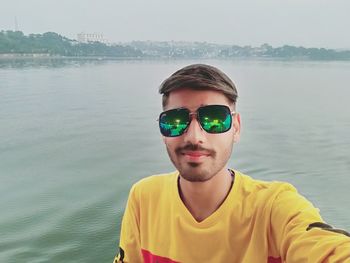 Portrait of young man wearing sunglasses at sea