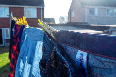 Close-up of clothes drying on clothesline against buildings in city