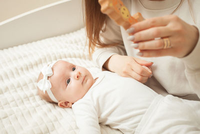 Mother plays with newborn baby, little girl explores world, looks at toy. early development, 