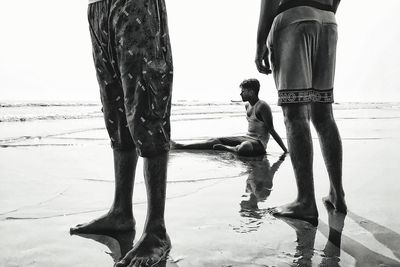 Low section of people walking on puddle