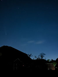 Low angle view of silhouette buildings against sky at night