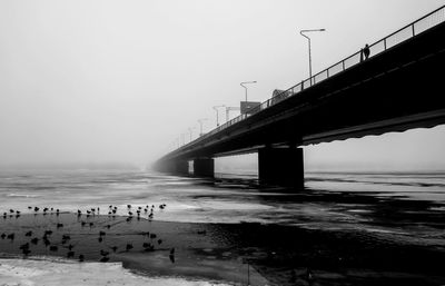 Bridge over sea against clear sky