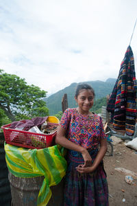 Portrait of smiling woman standing against mountains