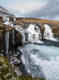 Scenic view of waterfall against sky