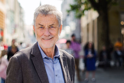 Close-up portrait of senior man standing in city