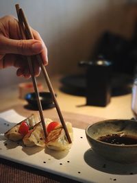 Close-up of hand holding food served in plate