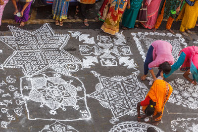High angle view of females making rangoli on footpath during competition