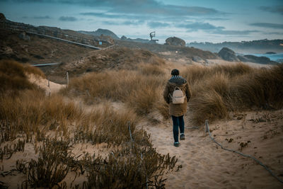 Woman walking through a beautiful dune area on the coast