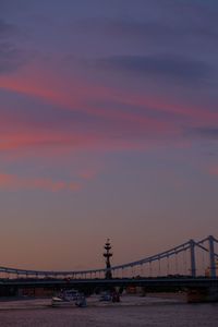 Bridge over river against sky during sunset