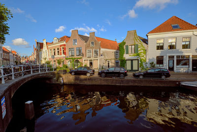  clear reflections of canal-side houses on the burgwal canal in haarlem on a sunny evening.