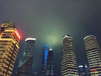 Low angle view of illuminated buildings against sky at night