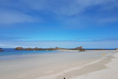 Scenic view of beach against blue sky