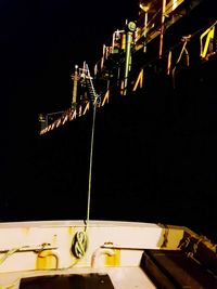 Low angle view of illuminated crane at night