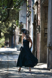 Woman with umbrella on street in city