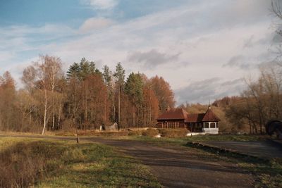 Houses by trees against sky