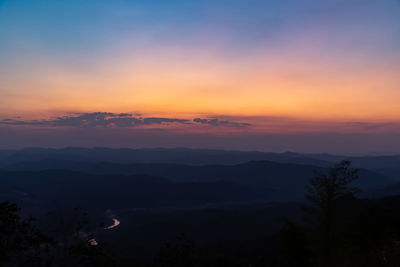 Scenic view of silhouette mountains against romantic sky at sunset