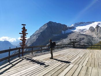 Rear view of people standing on snowcapped mountain