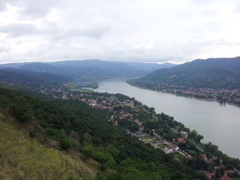 Scenic view of river and mountains against cloudy sky