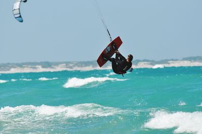Man kiteboarding over sea