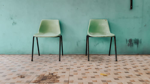 Empty chairs and tables against wall