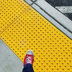 Low section of person standing on yellow floor