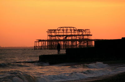 Silhouette single person against  west pier sunset 