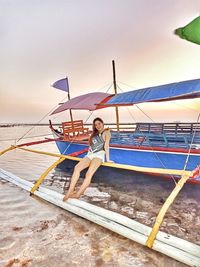 Portrait of young woman on land against sea