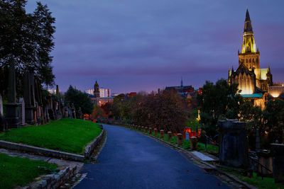 Street amidst buildings against sky at dusk