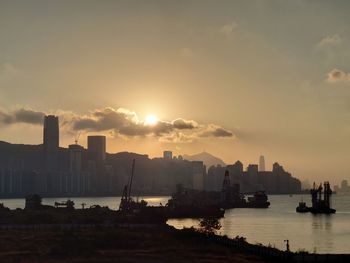 Scenic view of sea and buildings against sky during sunset