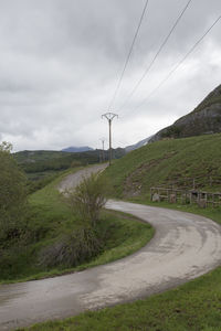 Road amidst green landscape against sky