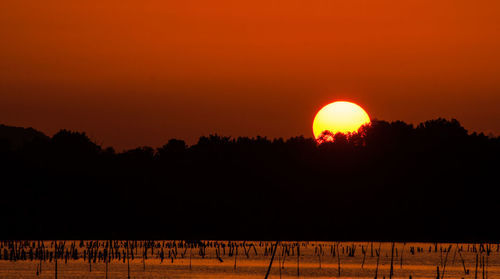 Scenic view of silhouette landscape against orange sky