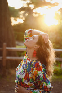 Woman looking away while standing outdoors