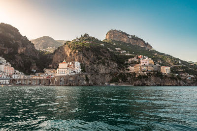 Scenic view of sea and mountains against clear sky