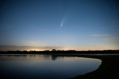 Scenic view of lake against sky at night
