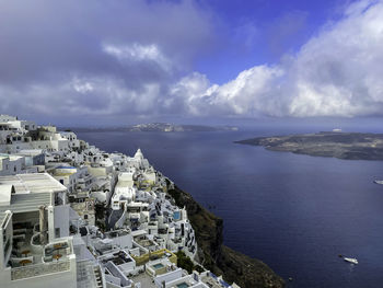 High angle view of townscape by sea against sky