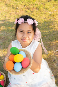 Portrait of cute girl holding easter eggs outdoors