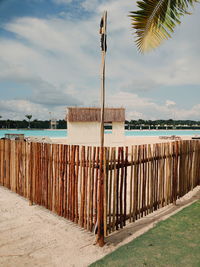 Wooden posts on beach against sky