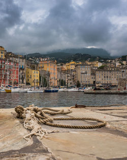 Sea by buildings in city against sky