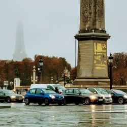 Cars on street by buildings against sky