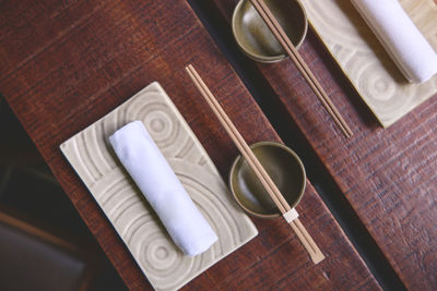 Japanese restaurant in traditional style, empty plate on mat near chopstick bowl, selective focus