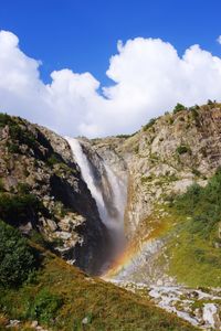 Slice of heaven in caucasian mountains, rainbow formed under glacial waterfall