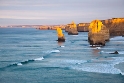 Rock formation in sea at the twelve apostles against sky