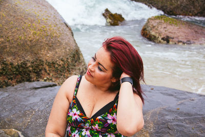 Young woman on rock at beach