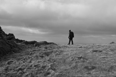 Rear view of man standing on land against sky