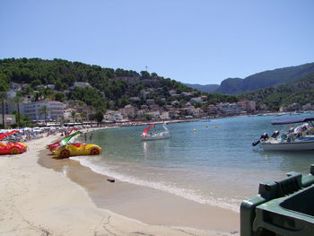 Boats moored on sea against clear sky